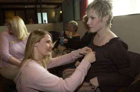 Trude McLaren pins a yellow ribbon on Nadine Ashley