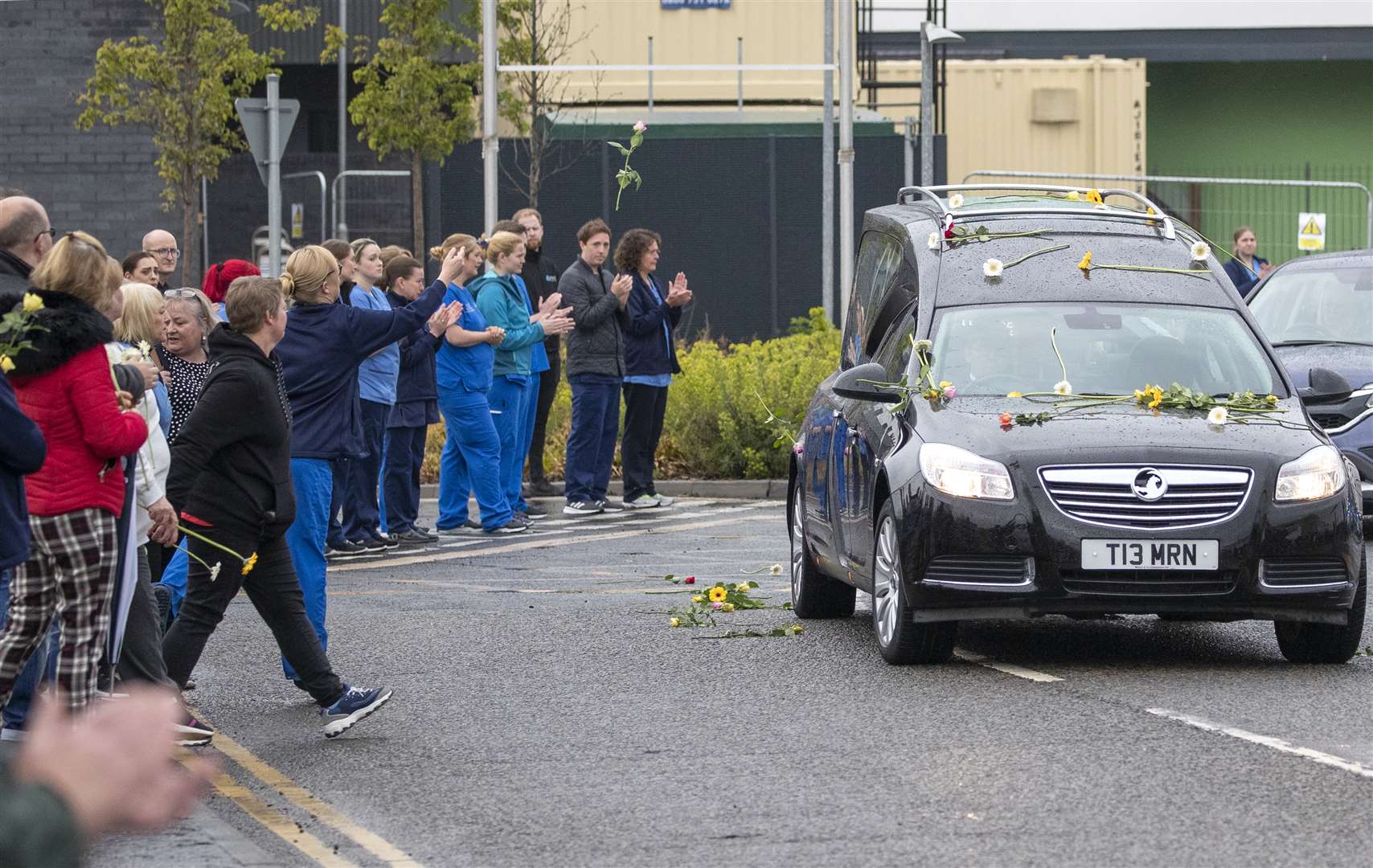 Colleagues threw flowers on to the hearse as it passed the hospital where Ms Murphy worked (Jane Barlow/PA)