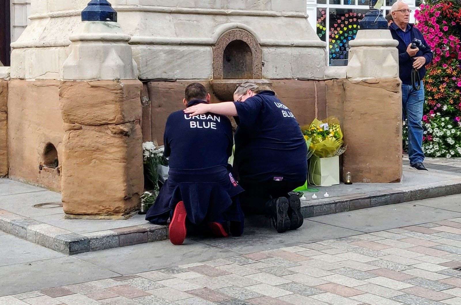 Volunteers console each other at the memorial to Andre Bent in Maidstone