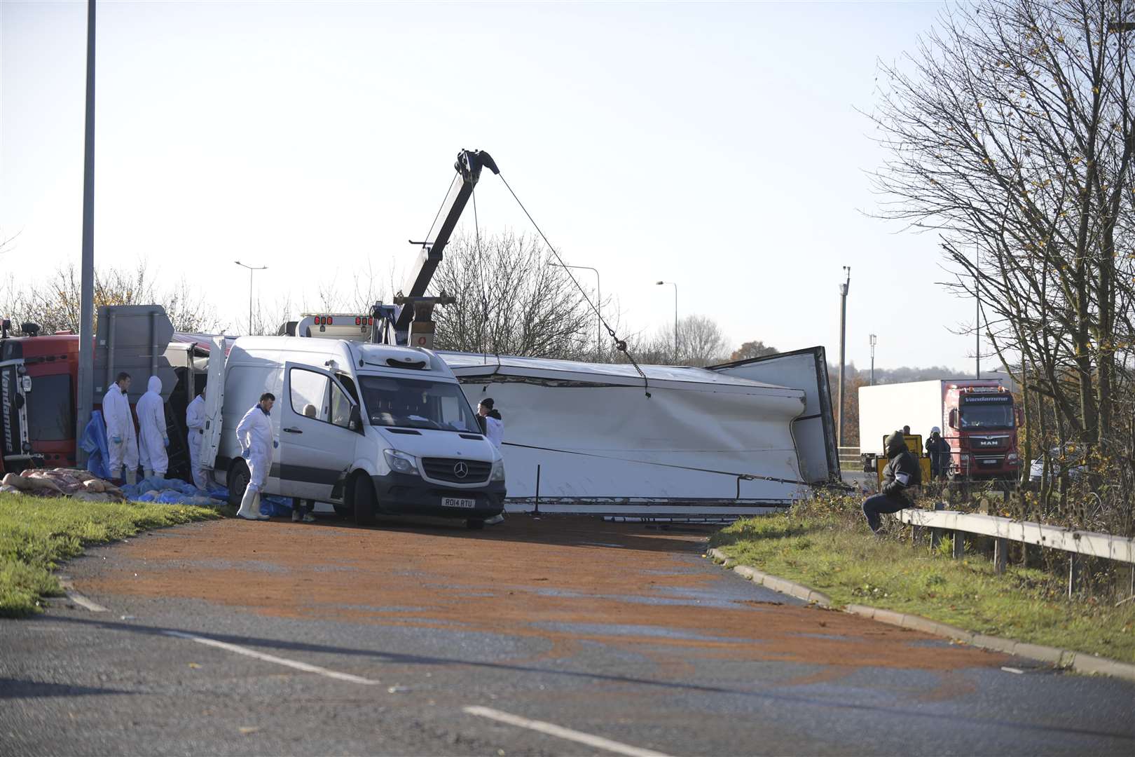 The contents are being unloaded into a small van before the truck can be lifted. Picture: Barry Goodwin