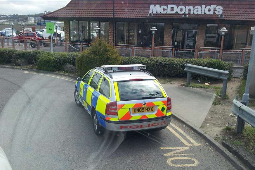 A police car parked on double yellow lines at the petrol station on the Medway City Estate