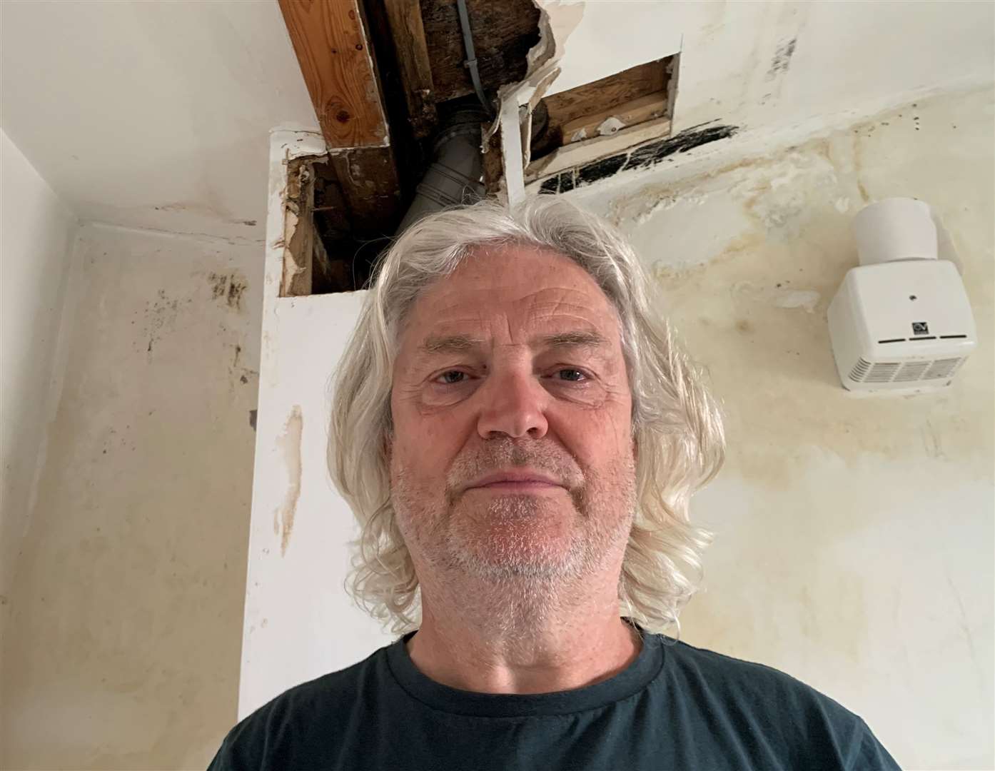 Peter Batt – pictured below a separate hole in his ceiling made to survey the damage – has been dealing with the issue with the block’s roof for six months