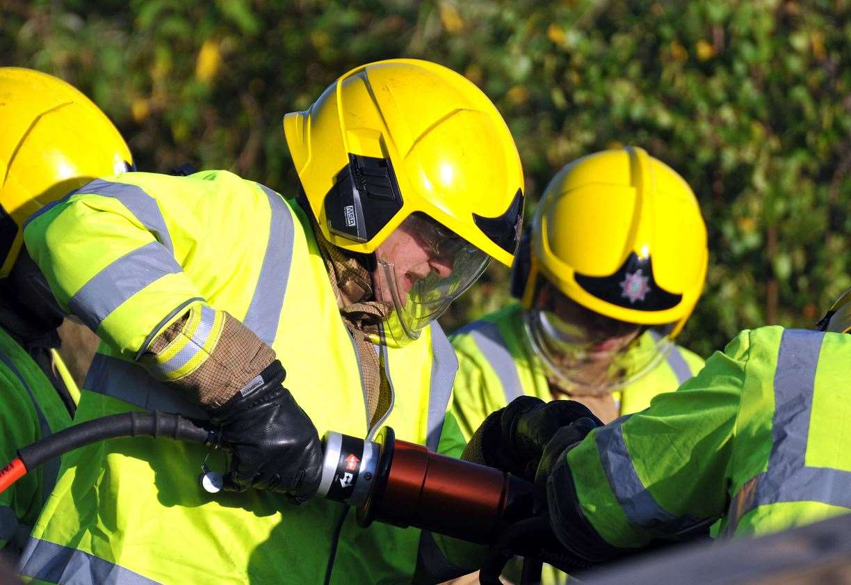 Fire crews using cutting gear to free the woman. Stock image