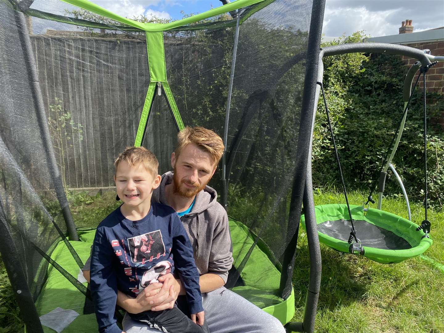 Owen Houlton with son Hunter, a four-year-old with severe autism who uses the trampoline and swing set the council has ordered must be removed