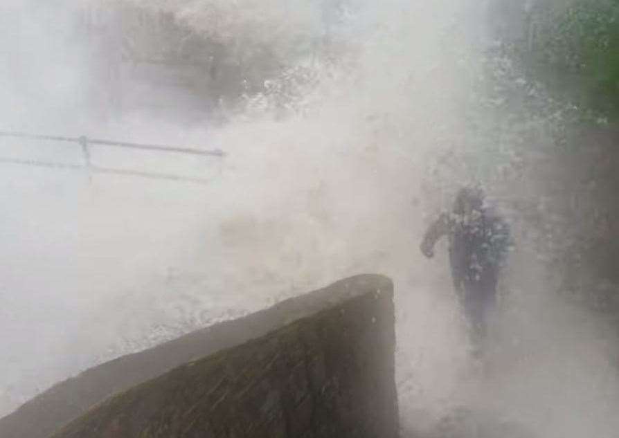 One of the boys is swept off his feet by the wave