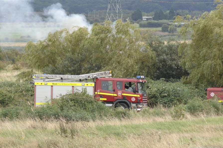 Firefighters tackling a grass fire. Stock image