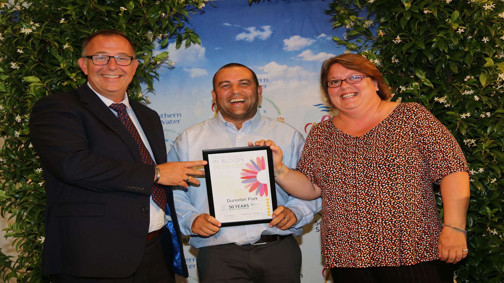 Sharon Carter, TWBC, and Dan Dibden, contract manager for Sodexo, collecting the award for large park from celebrity gardener Chris Collins