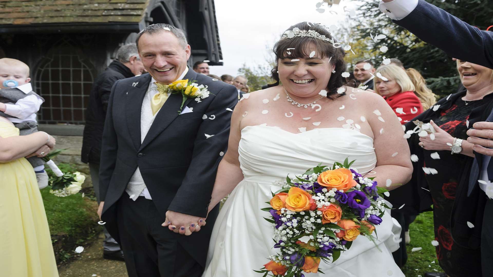 Guests throw confetti as Robin and Ann walk by