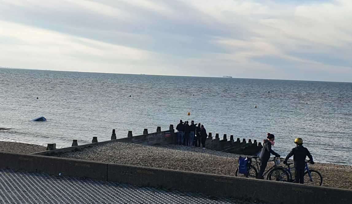 Onlookers watching the car be claimed by the sea on Saturday evening