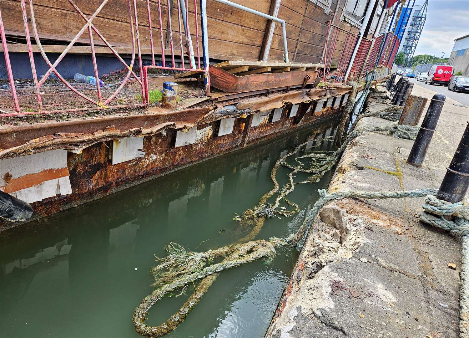 The steel barge is crashing against the pier wall causing it crumble