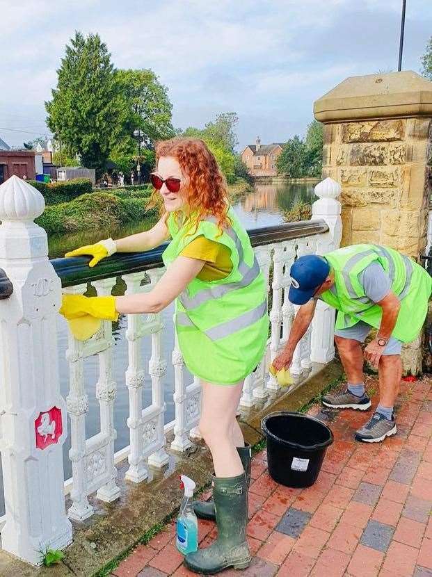 Anna Cope cleaning the Tonbridge Bridge ahead of the annual Dragon Boat Race