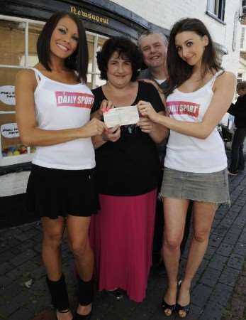 Sue Niblett and husband Jeff receive a cheque from Sport models Aaliyah and Danielle.