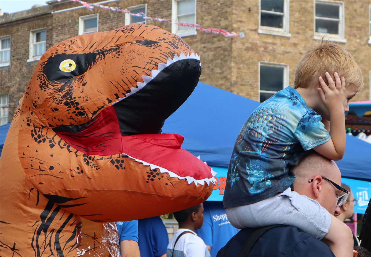 A young boy not enjoying an inflatable dinosaur's roars at Sheerness Seaside Festival. Picture: John Nurden