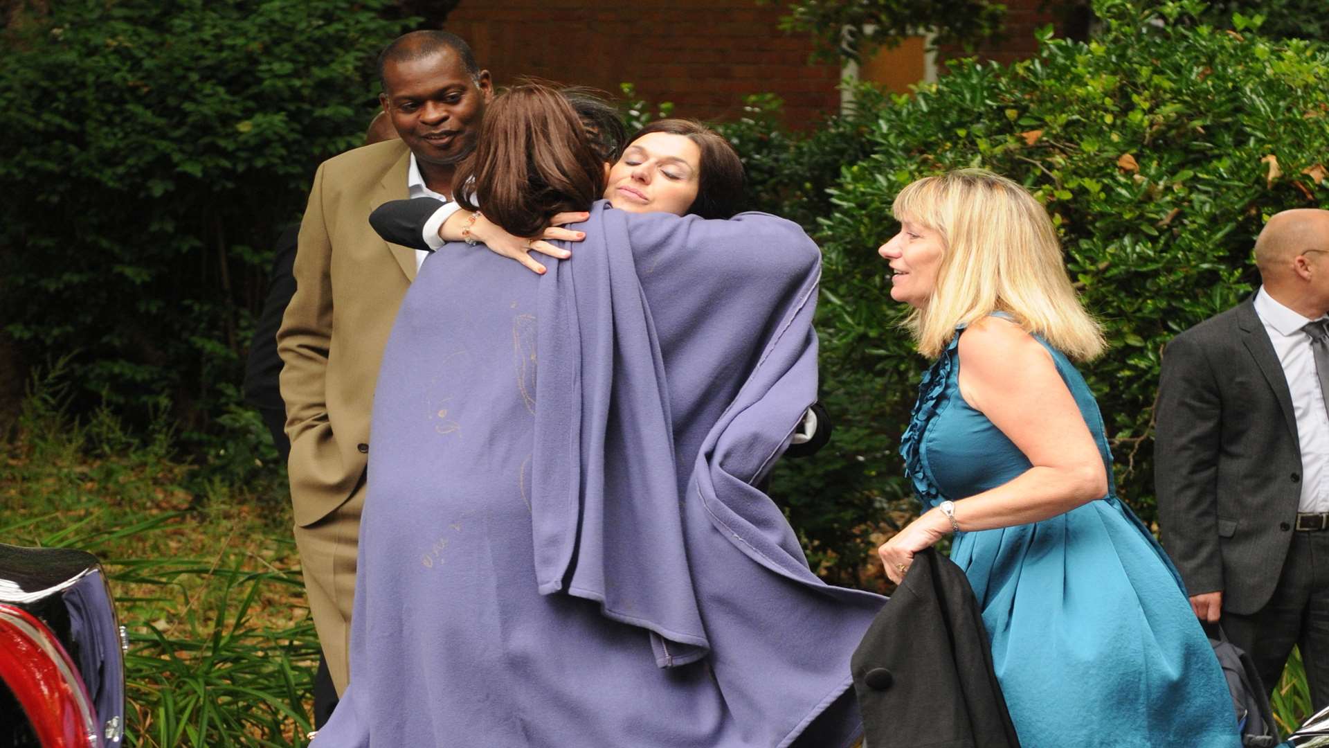 Mourners outside the church comfort each other.