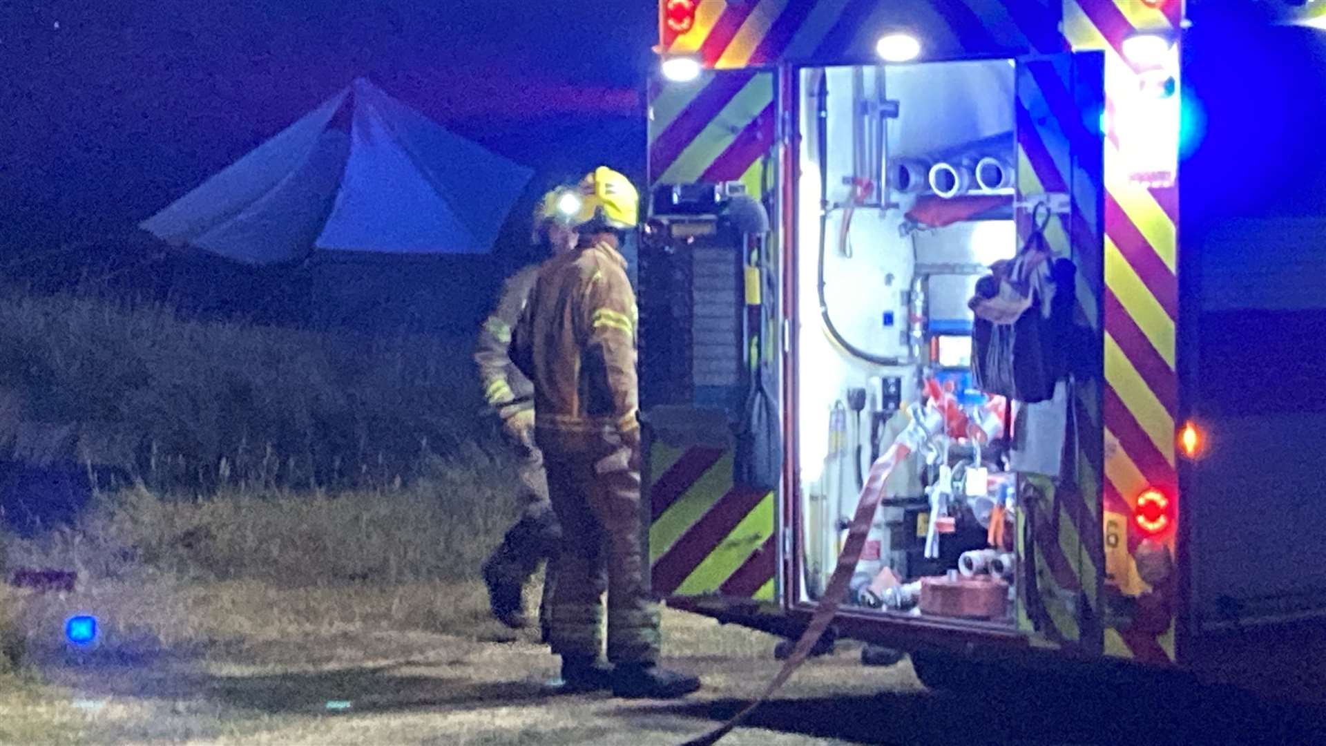 Firefighters tackle burning grass following a model aeroplane display at Barton's Point Coastal Park, Sheerness. Picture: John Nurden