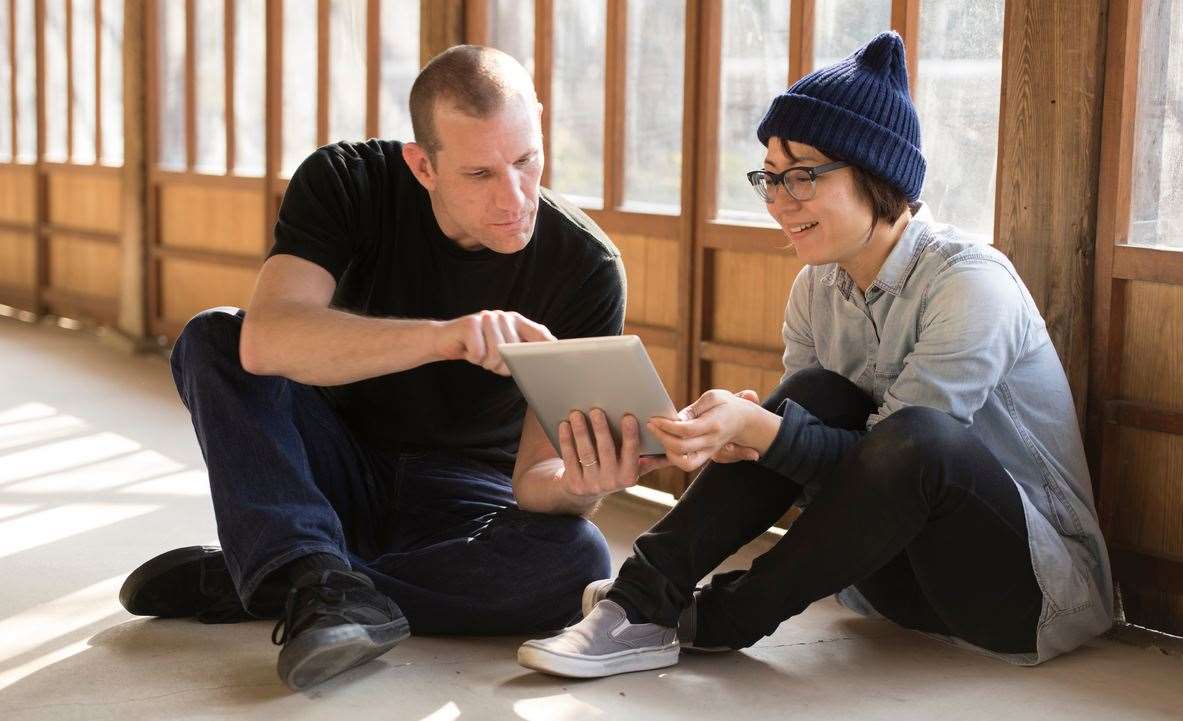 Volunteer work comes in all shapes and sizes. Here, a volunteer uses a tablet to assist somebody in need of help.