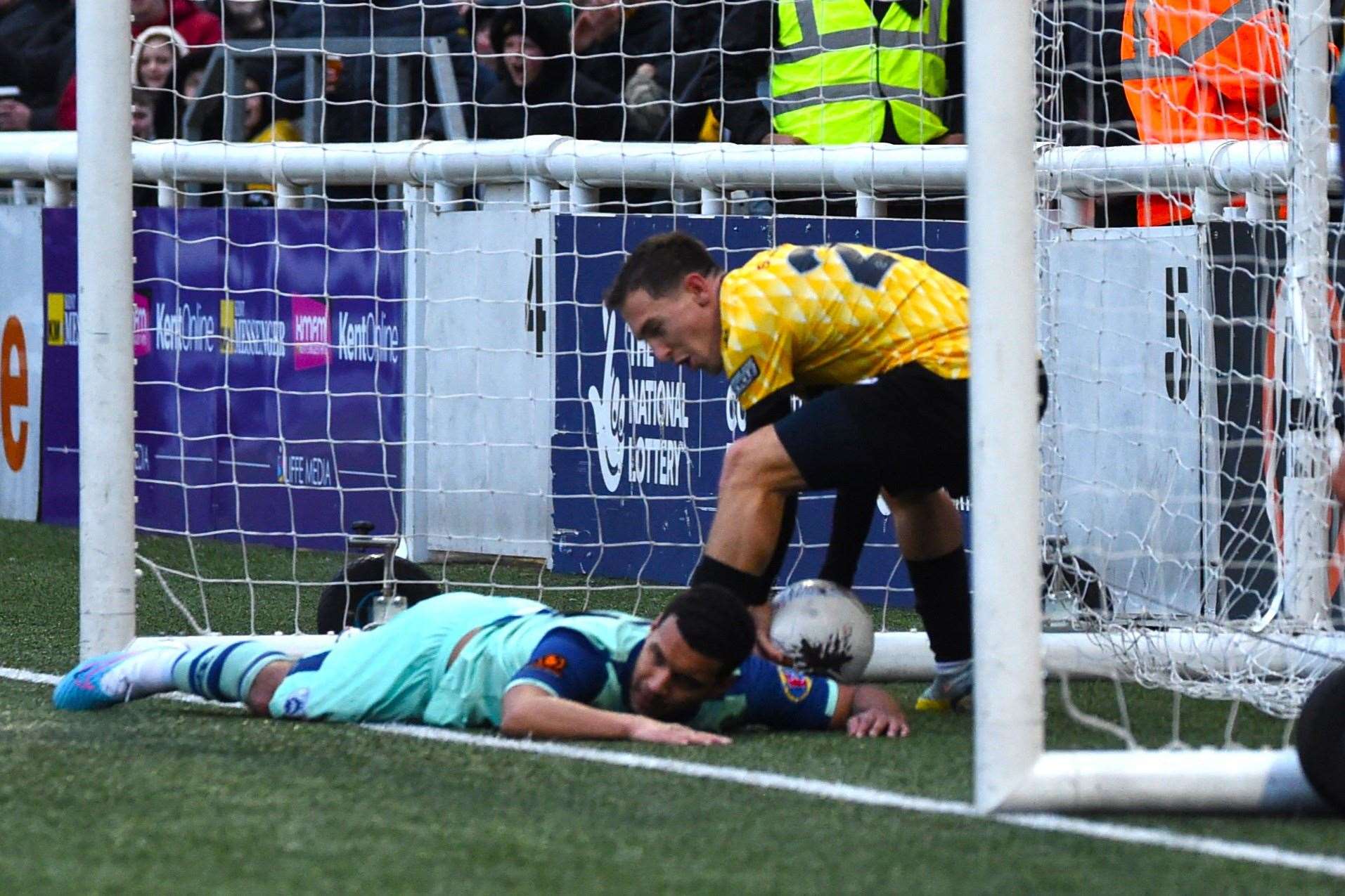 Angels defender Kodi Lyons-Foster ends up in the net after his part in Jonny Henly’s own goal. Picture: Steve Terrell