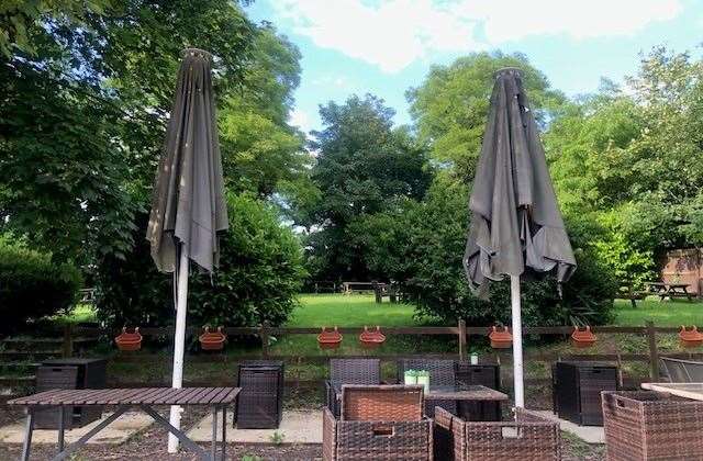 Beyond this seating area, with two large umbrellas there is an extensive garden area with a large number of picnic tables