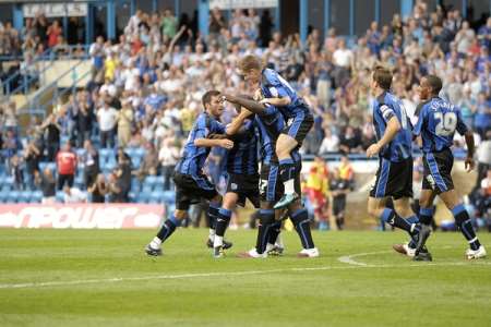 Bayo Akinfenwa celebrates scoring the equaliser with fellow Gills players