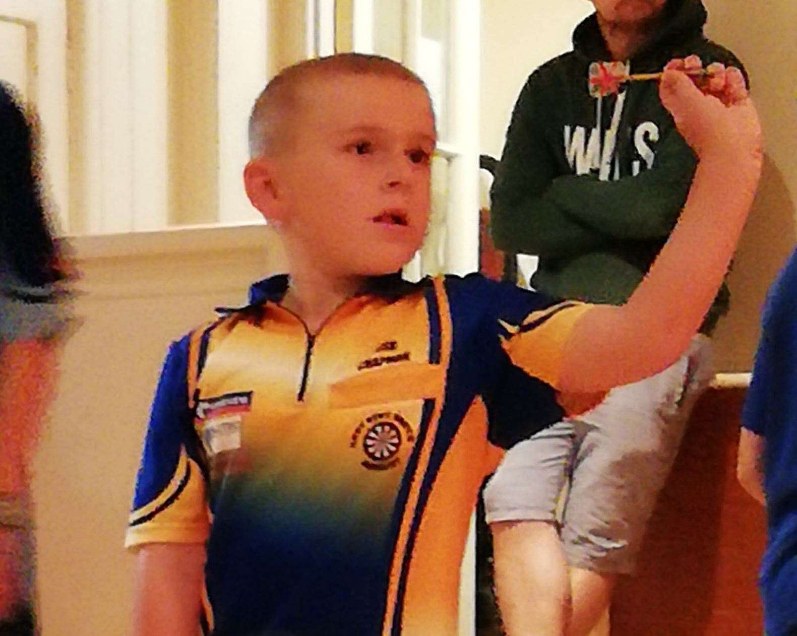 Young darts player Joshua Chapman toeing the oche