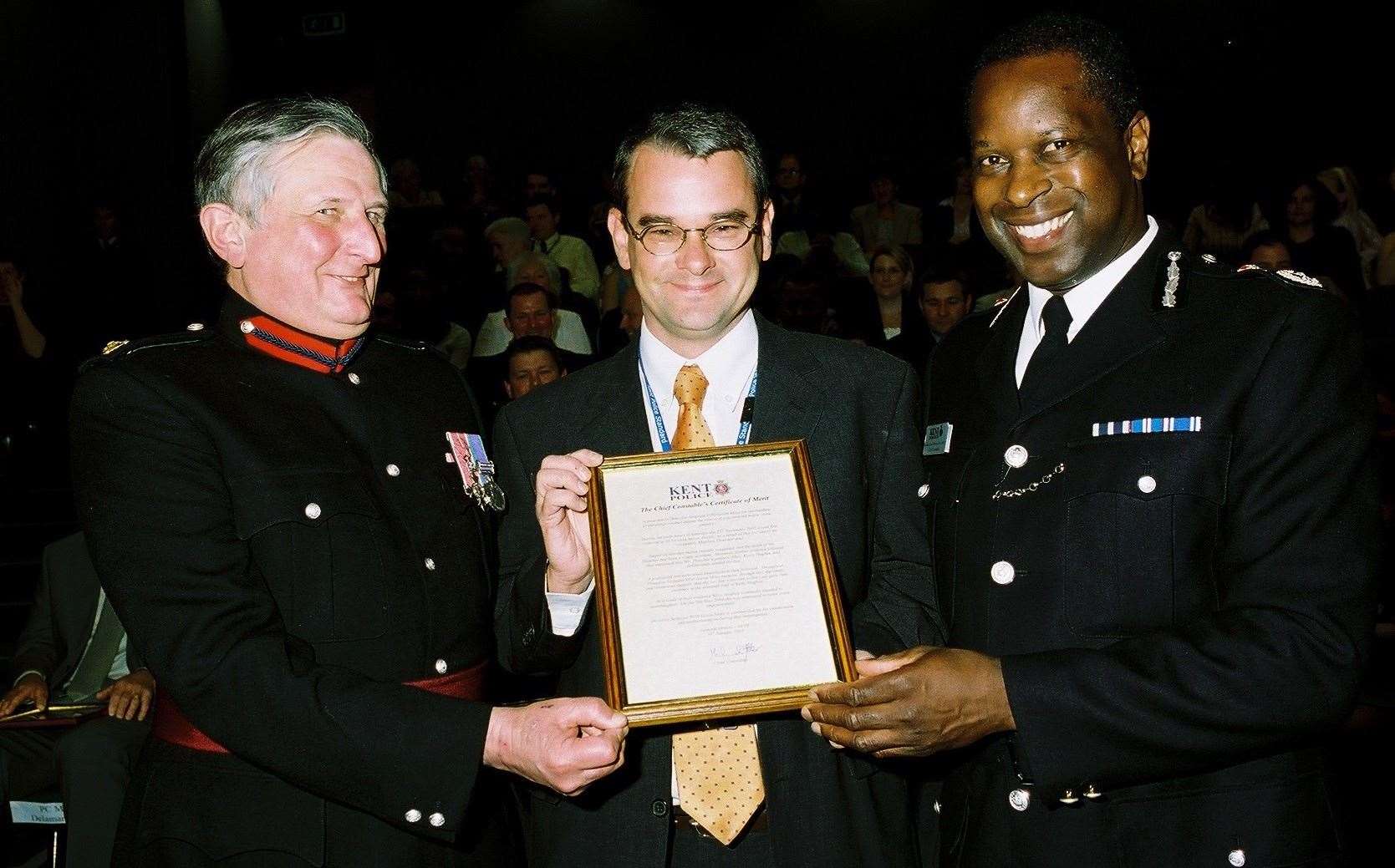 CAPTION: l-r Vice Lord Lieutenant of Kent, Viscount De L'Isle MBE, DS Gavin Moss with his certificate and then-Chief Constable Mike Fuller. Picture: Colin Topley