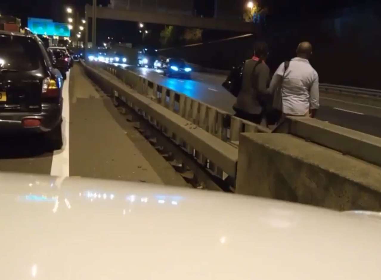 Two people poised at the edge of the M25 ready to make a dash across. Picture: Kieran Medicman1987 on Twitter