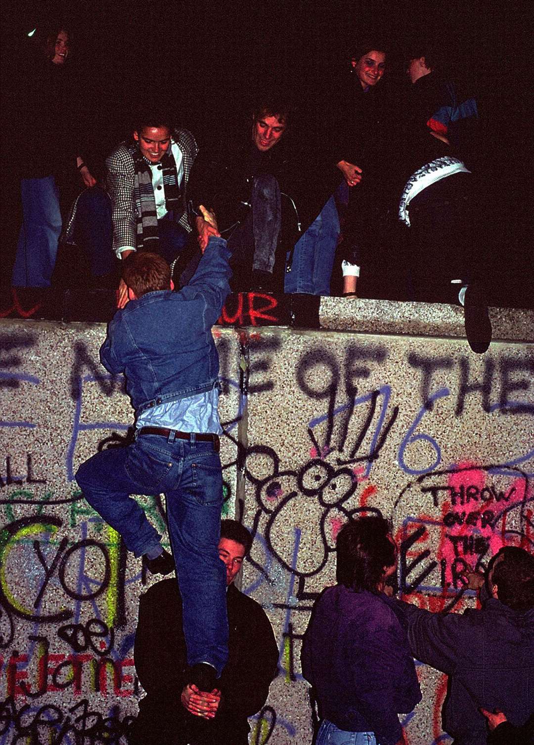 People climbing the Berlin Wall on November 9, 1989. Picture: iStock/PA