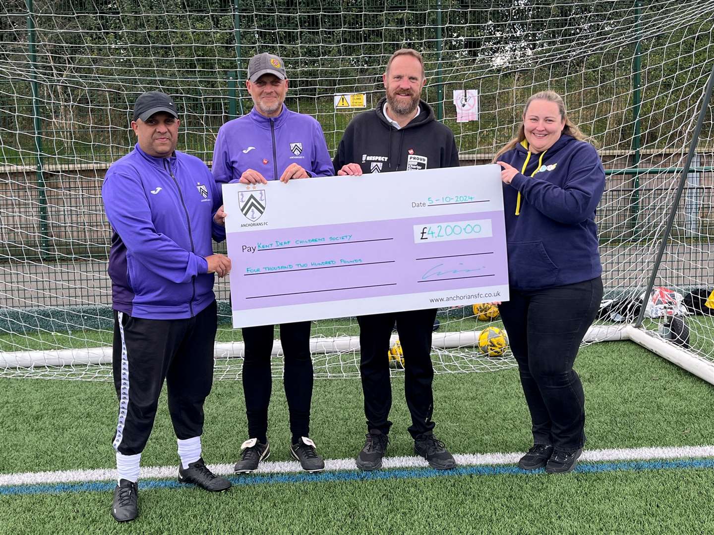 Kerry Shadick from the Kent Deaf Children's Society is presented with a cheque by Leigh Willis, who is joined by two of the club's coaches