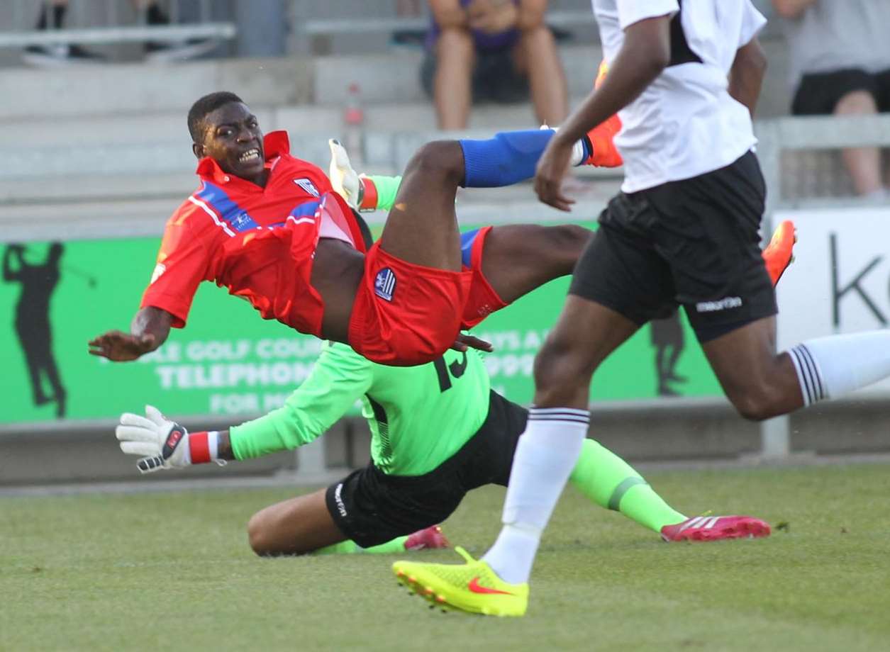 Gillingham's Jermaine McGlashan is taken out by Dartford keeper Deren Ibrahim Picture: John Westhrop