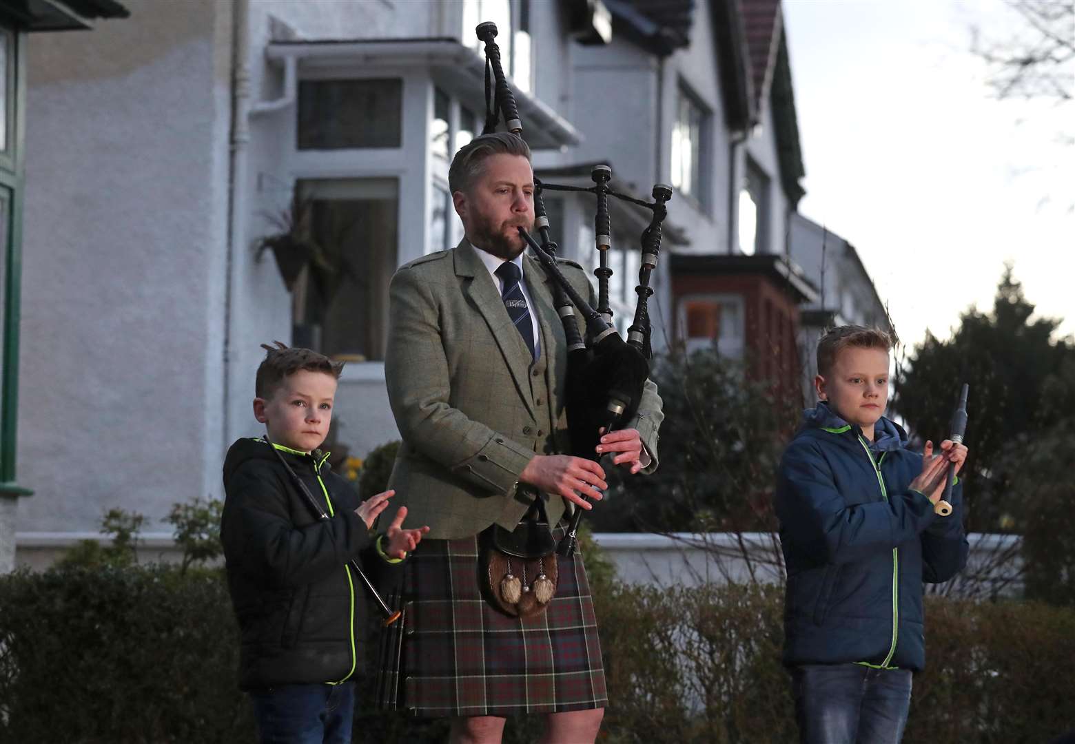 In Glasgow, Finlay MacDonald played the pipes outside his home alongside sons Elliott, 10, and Fionn, eight to salute local heroes during Thursday’s nationwide Clap for Carers NHS initiative to applaud NHS workers fighting the coronavirus pandemic (PA)