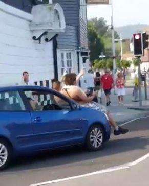 In high spirits, two men lean back on the bonnet. Picture credit: Gross Gore on Twitter