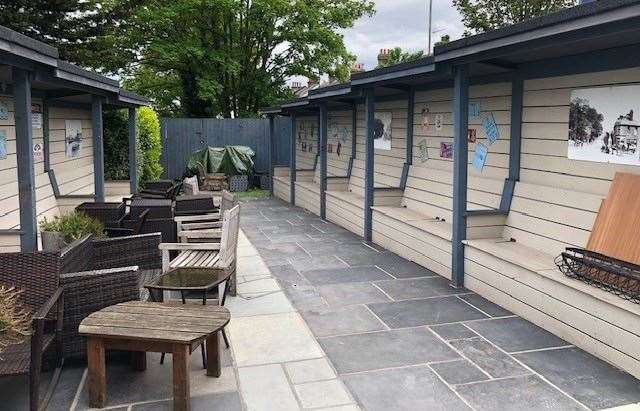 These individual seating areas are positioned on both sides of the pub’s narrow space outside