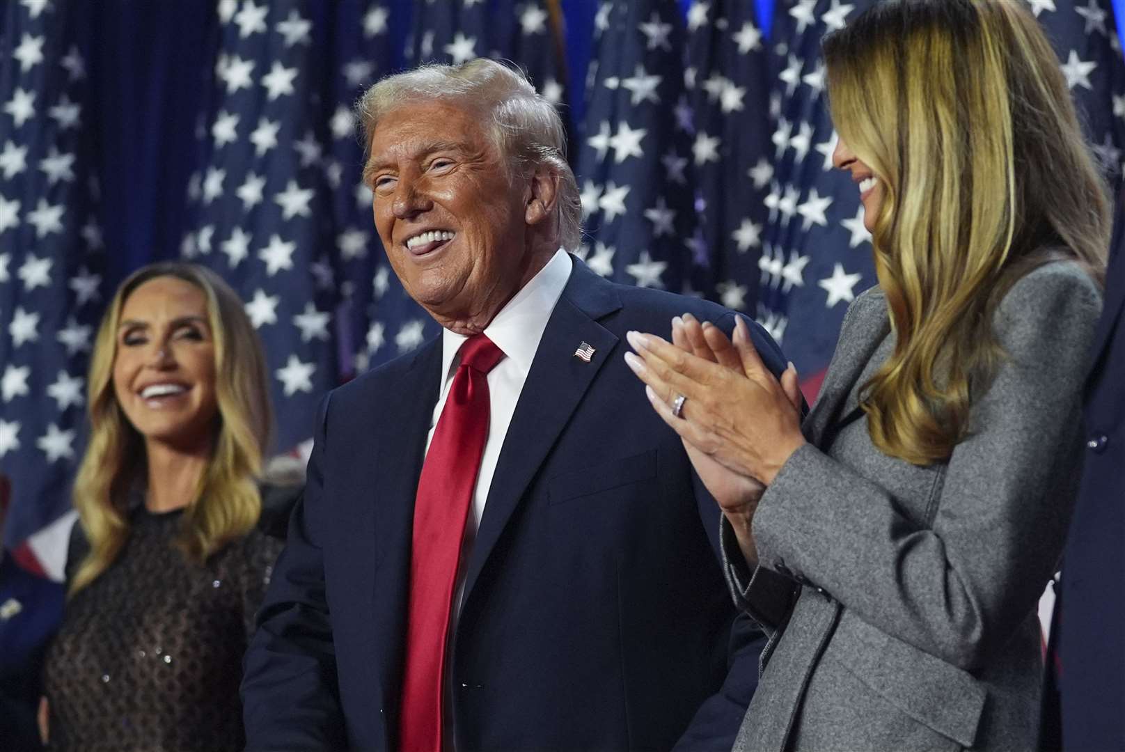 Republican presidential nominee former President Donald Trump stands on stage with former first lady Melania Trump, as Lara Trump watches, at an election night watch party (Evan Vucci/AP)