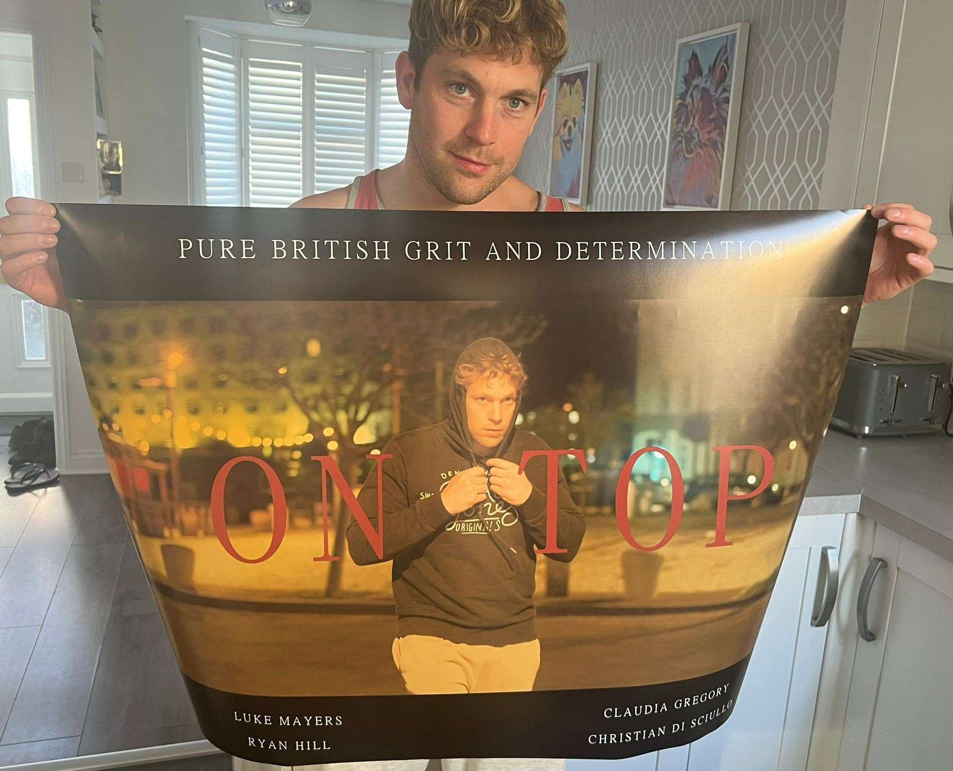 Luke Mayers in front of his movie poster