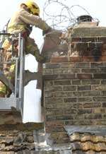 A firefighter examines a damaged chimney on April 28 last year. Picture: Paul Dennis