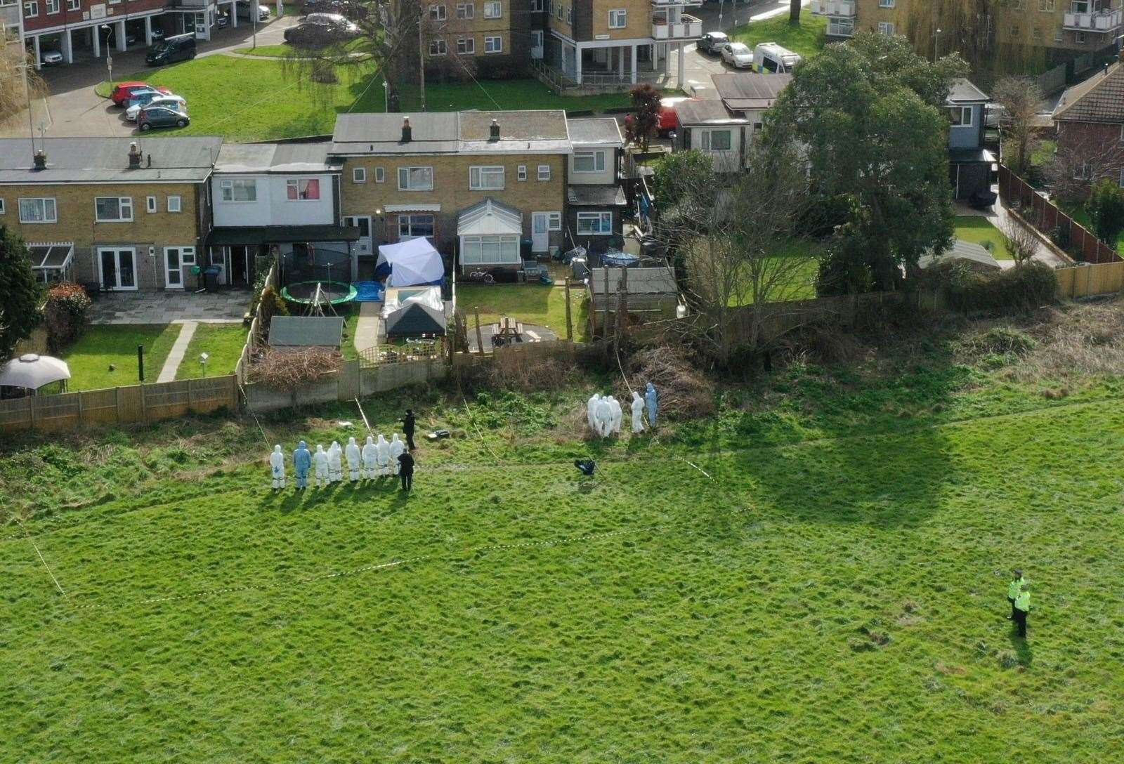 Forensics officers search fields that back on to Wayne Couzens' home Picture: UKNIP