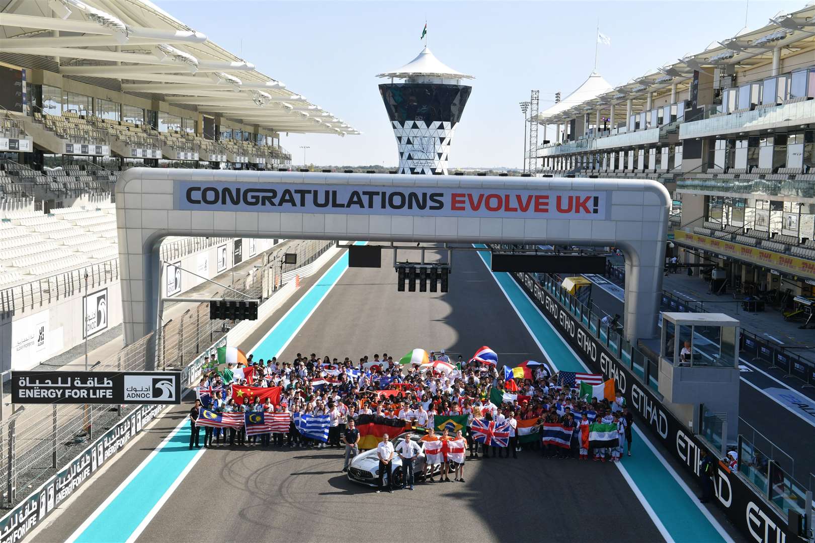 F1 in Schools finalists celebrating on the grid at the Yas Marina Circuit in Abu Dhabi