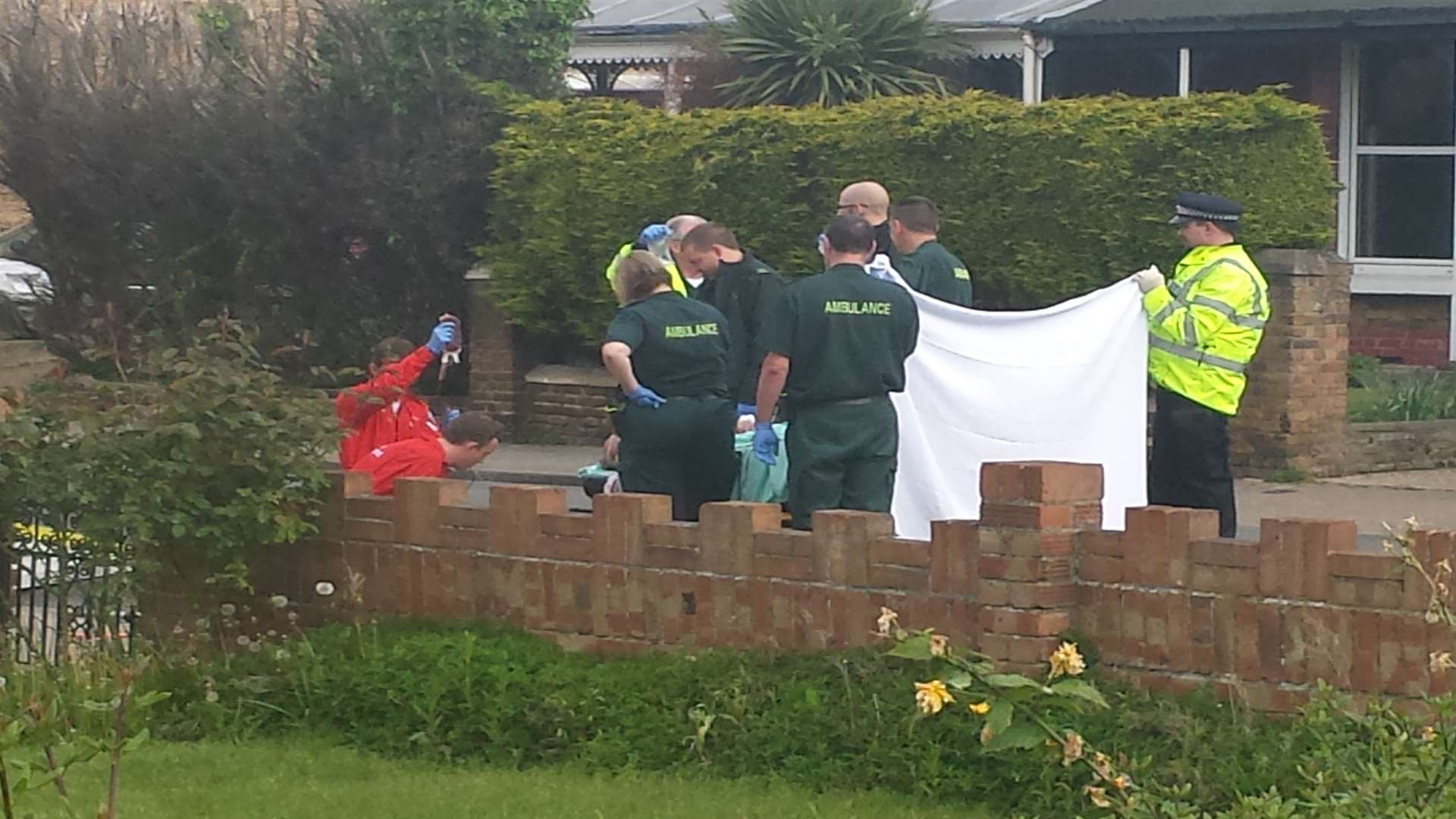 Paramedics treat the injured man behind a screen