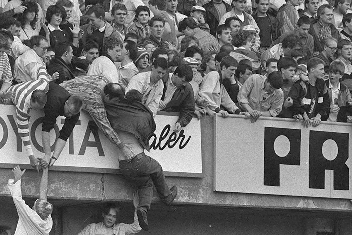 Football fans climb to safety during the crush at Hillsborough. Picture: Ross Parry/Sheffield Star