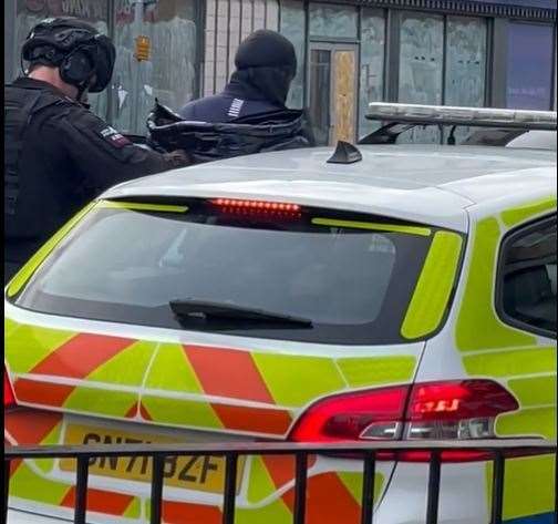 A man is put into the back of a police car in handcuffs. Pic: Mason Cran