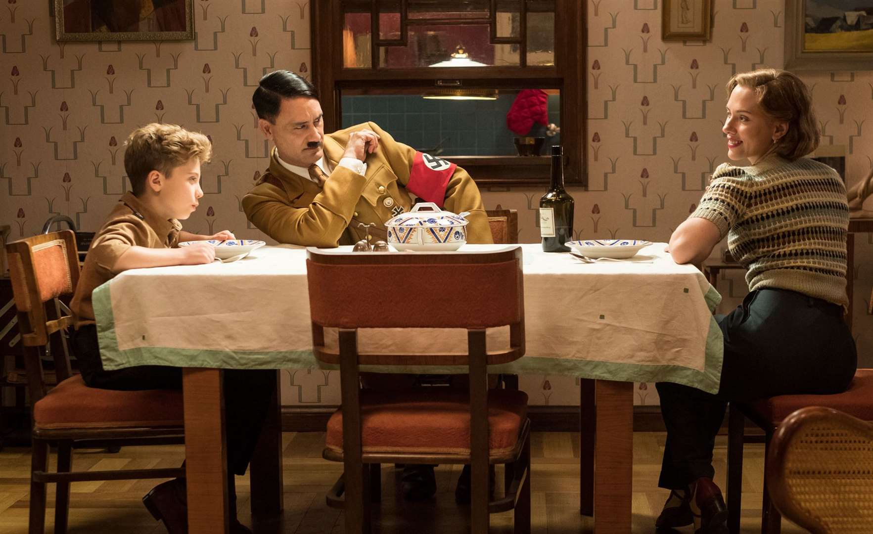 Jojo Rabbit. Pictured: Roman Griffin Davis as Jojo Betzler, Taiki Waititi as Adolf Hitler and Scarlett Johansson as Rosie Betzler Picture: PA Photo/Twentieth Century Fox Film Corporation/Kimberley French