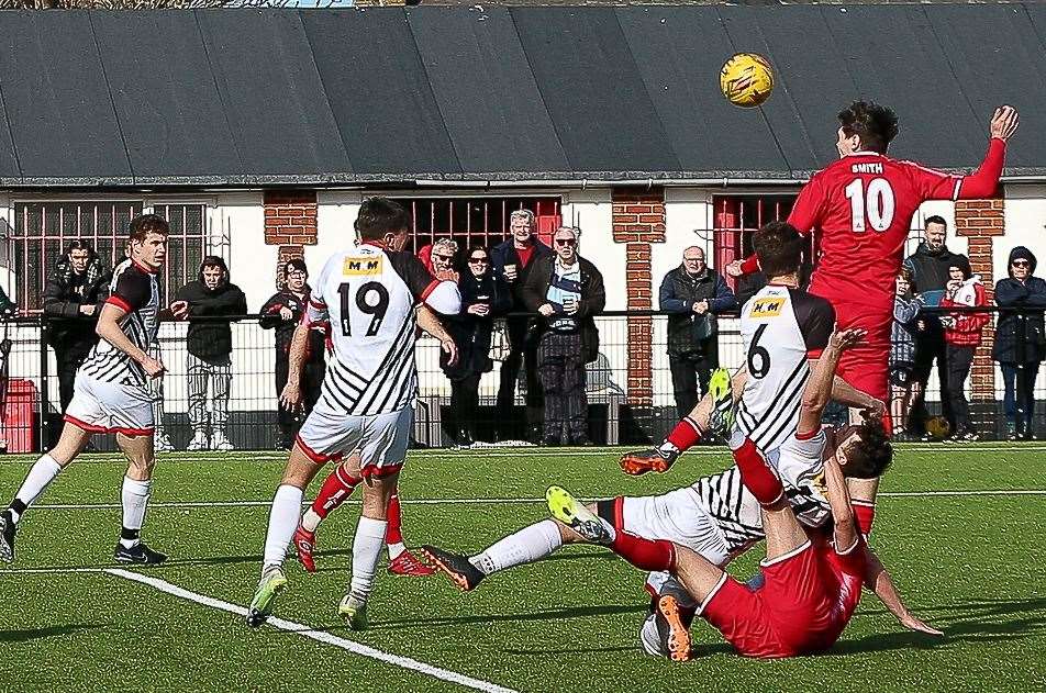 Whitstable substitute Harvey Smith scores with a header after beating Deal's Billy Munday to the ball in the Oystermen’s 3-2 Easter Monday defeat. Picture: Les Biggs