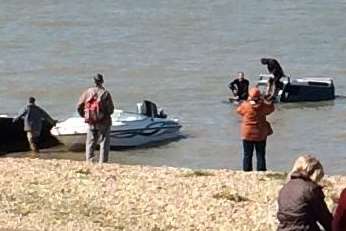 Onlookers stare in disbelief after this car was left stranded in the sea