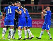 Gills players mob Jack Payne after the midfielder restored their lead with around 15 minutes remaining.