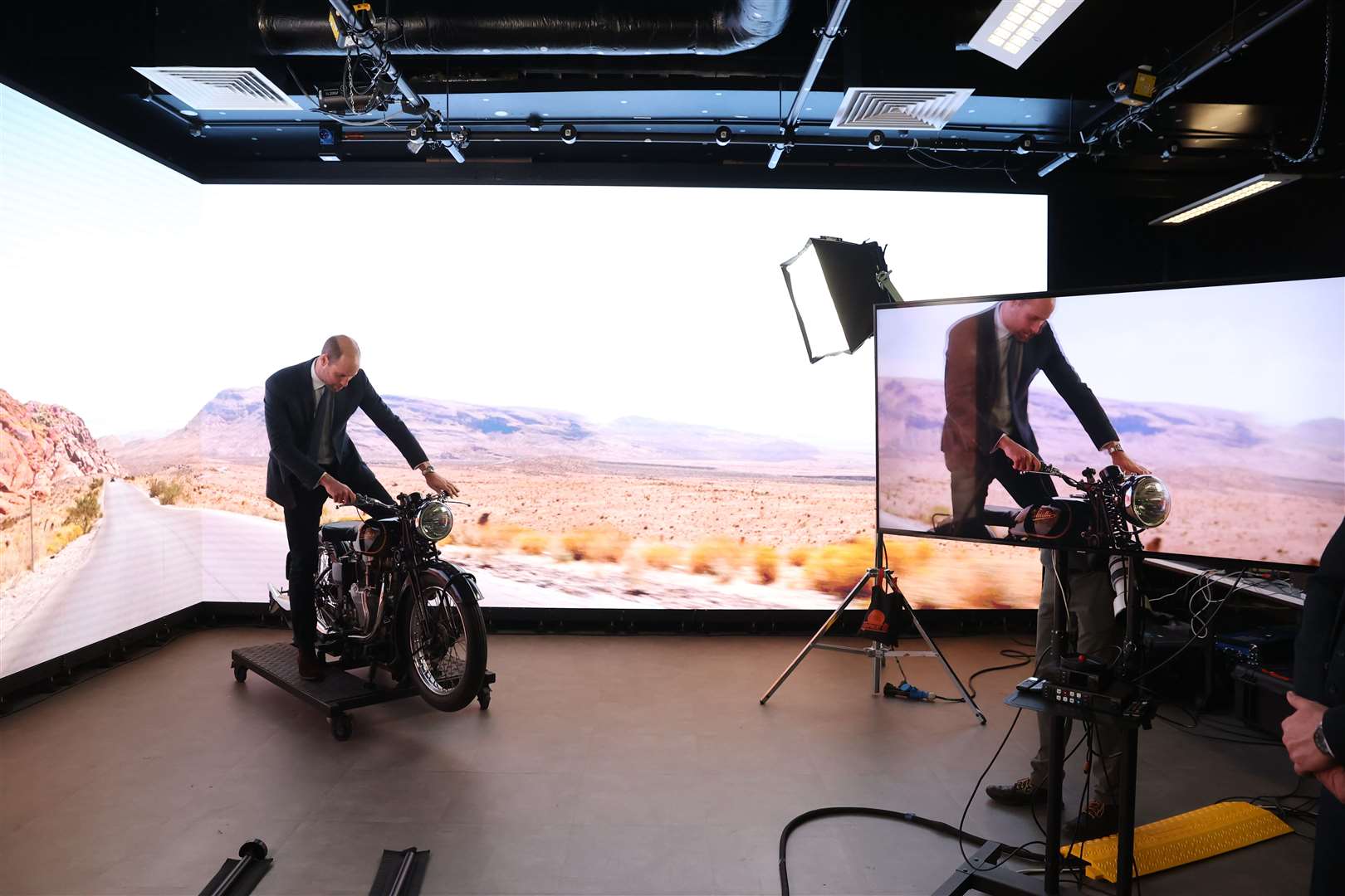 The Prince of Wales tries out a motorbike in the state-of-the-art virtual production studio at Ulster University in Belfast (Liam McBurney/PA)