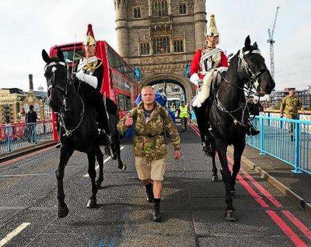 Christian Nock crosses Tower Bridge in walk around the British coast.