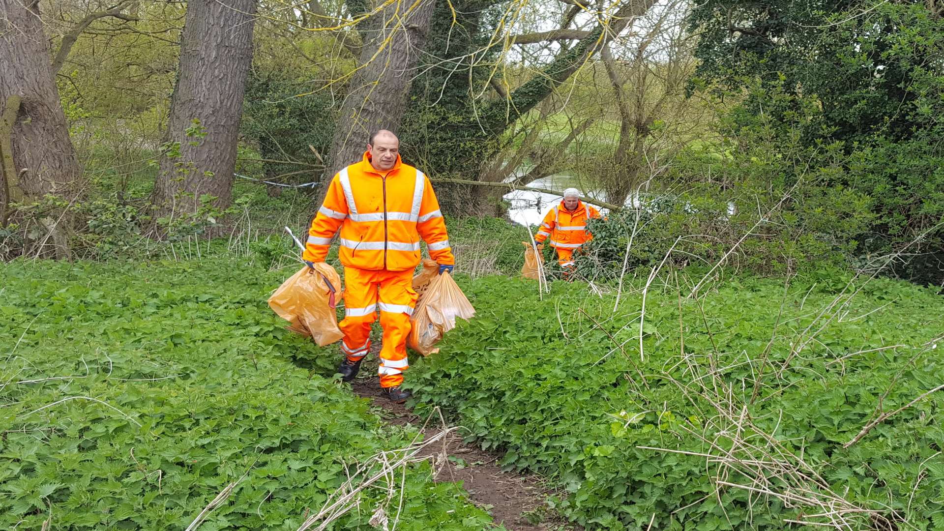 Serco workers carry bags from the scene