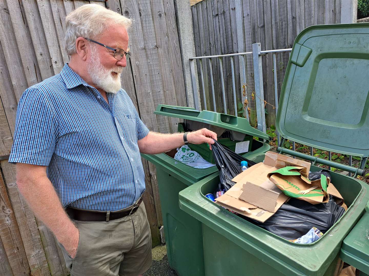 Brian Beswick picking out the black plastic sack that has caused this recycling bin at Bluecoats Yard to be rejected