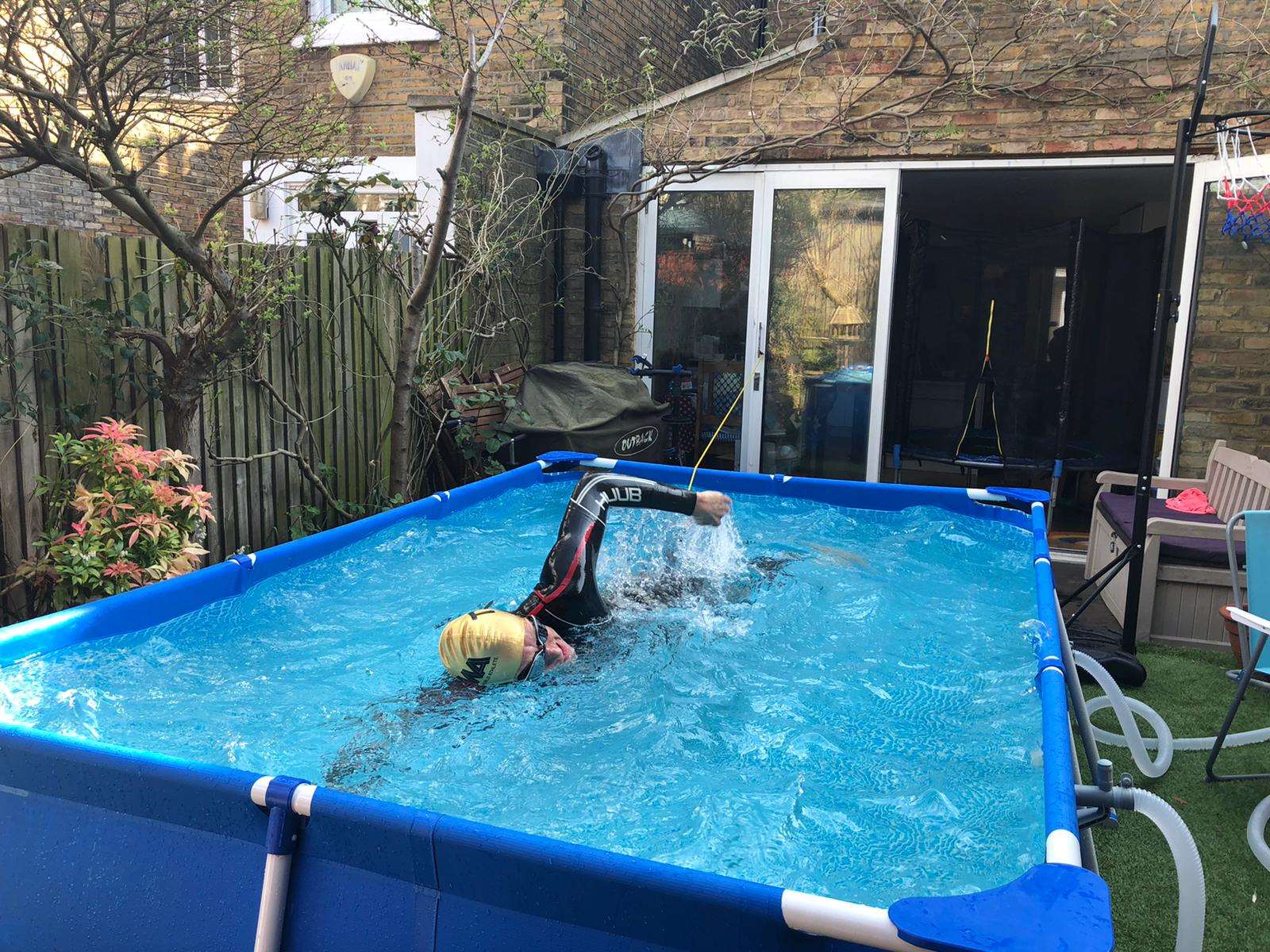 Neil Clark completed the swim leg of the triathlon in a 3m pool while tethered to the patio doors (Neil Clark/PA)