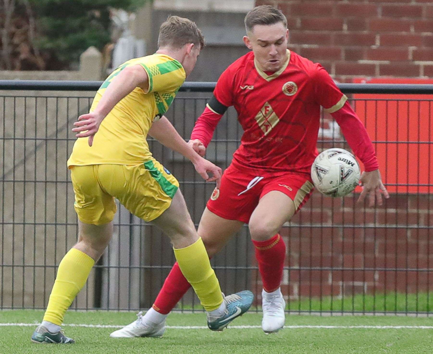 Whitstable’s Josh Oliver (red) is up against Lydd’s Elliott Moore in their FA Vase second round clash on Saturday. Picture: Les Biggs